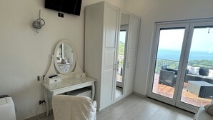 A modern bedroom with a large sliding glass door leading to a balcony with a view of the ocean. - Villa Asia (Massa Lubrense)