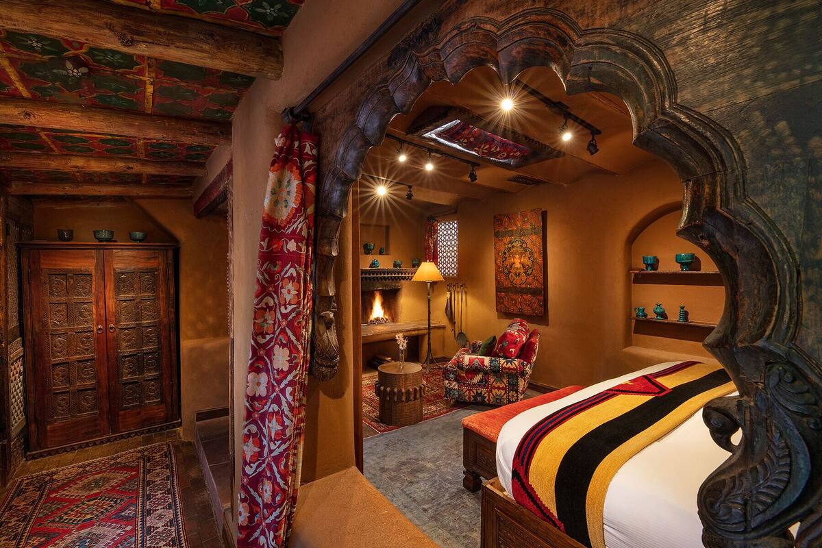 A traditional room with a wooden bed, a fireplace, and ornate decor.