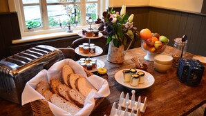 A breakfast buffet with various food items, including bread, fruits, and condiments. - The Thomas Lord (Petersfield)