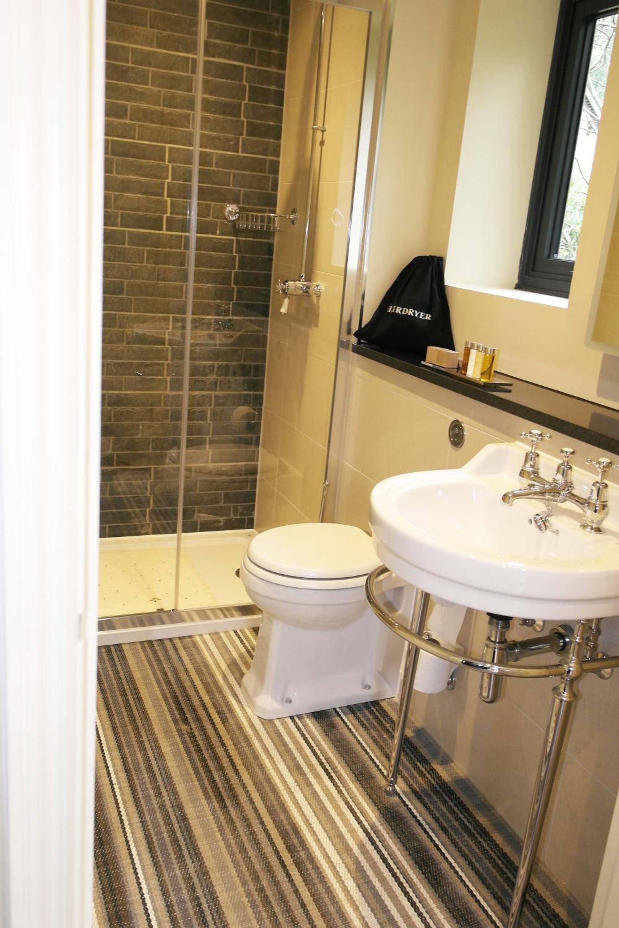 A bathroom with a shower, toilet, and sink.