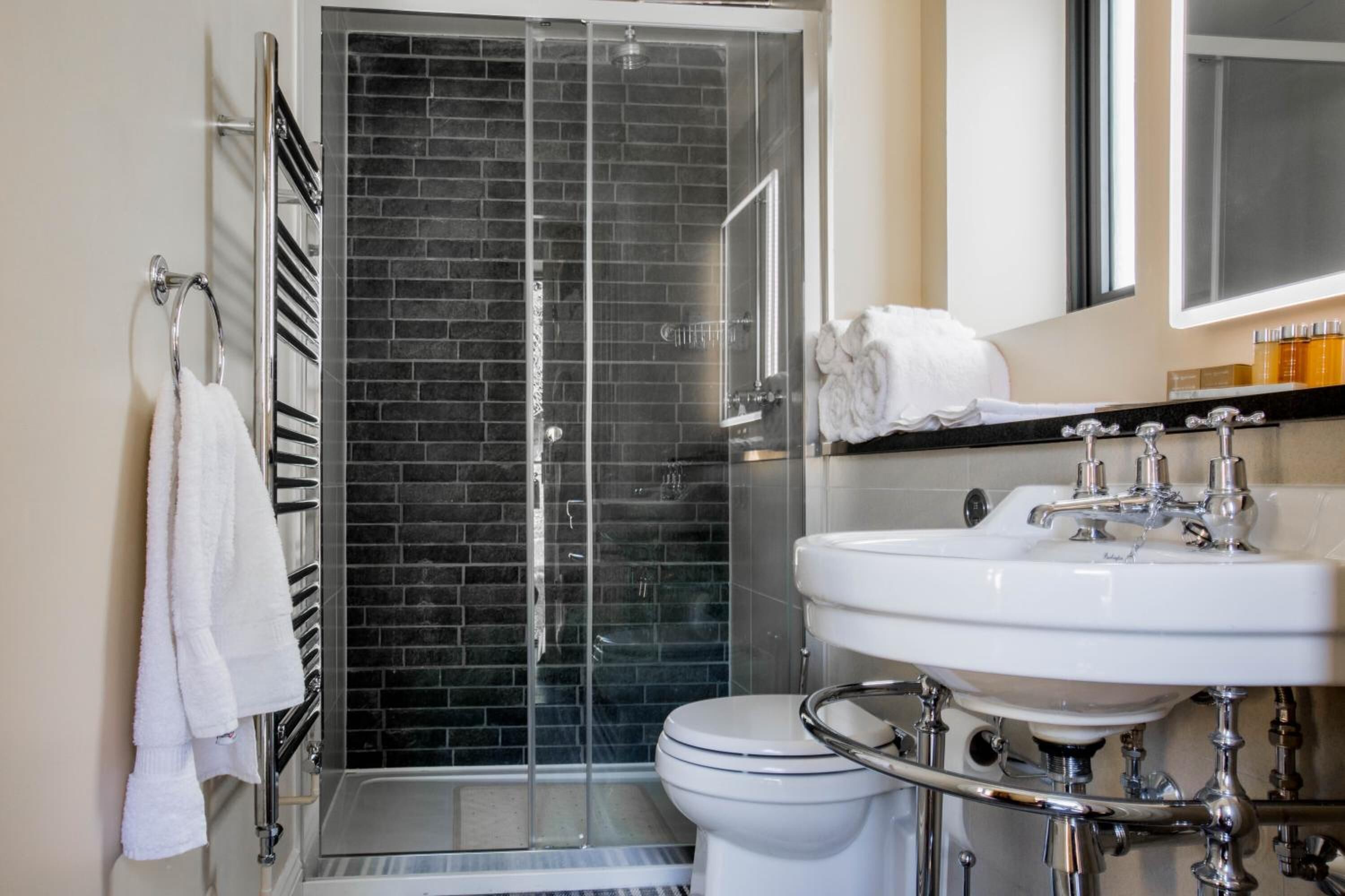 Douche, articles de toilette de luxe, sèche-cheveux, serviettes fournies