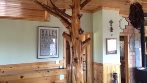 A wooden interior with a ceiling fan, a wooden bench, a framed sale sign, and a statue. - Off the Grid, secluded, Hamm's Hideaway (quemado)