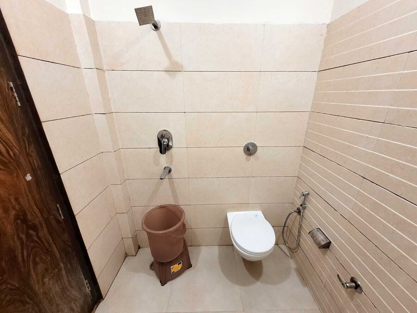 A small, tiled bathroom with a toilet, bidet, and shower.