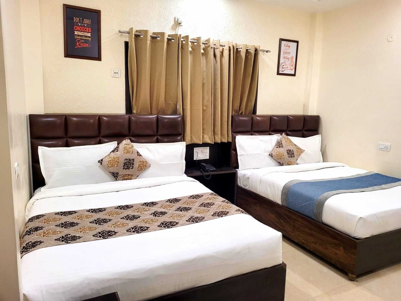 Ein Hotelzimmer mit zwei Betten, jeweils mit Kopfstütze, weißer Bettwäsche und dekorativen Kissen.