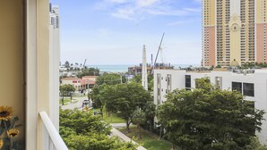 A high-rise building with a view of the ocean and a construction crane in the background. - Modern 2BR/2BA Ocean View Beach Condo STR-09902 (Sunny Isles Beach)
