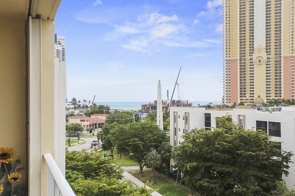 A high-rise building with a view of the ocean and a construction crane in the background. - Modern 2BR/2BA Ocean View Beach Condo STR-09902 (Sunny Isles Beach)