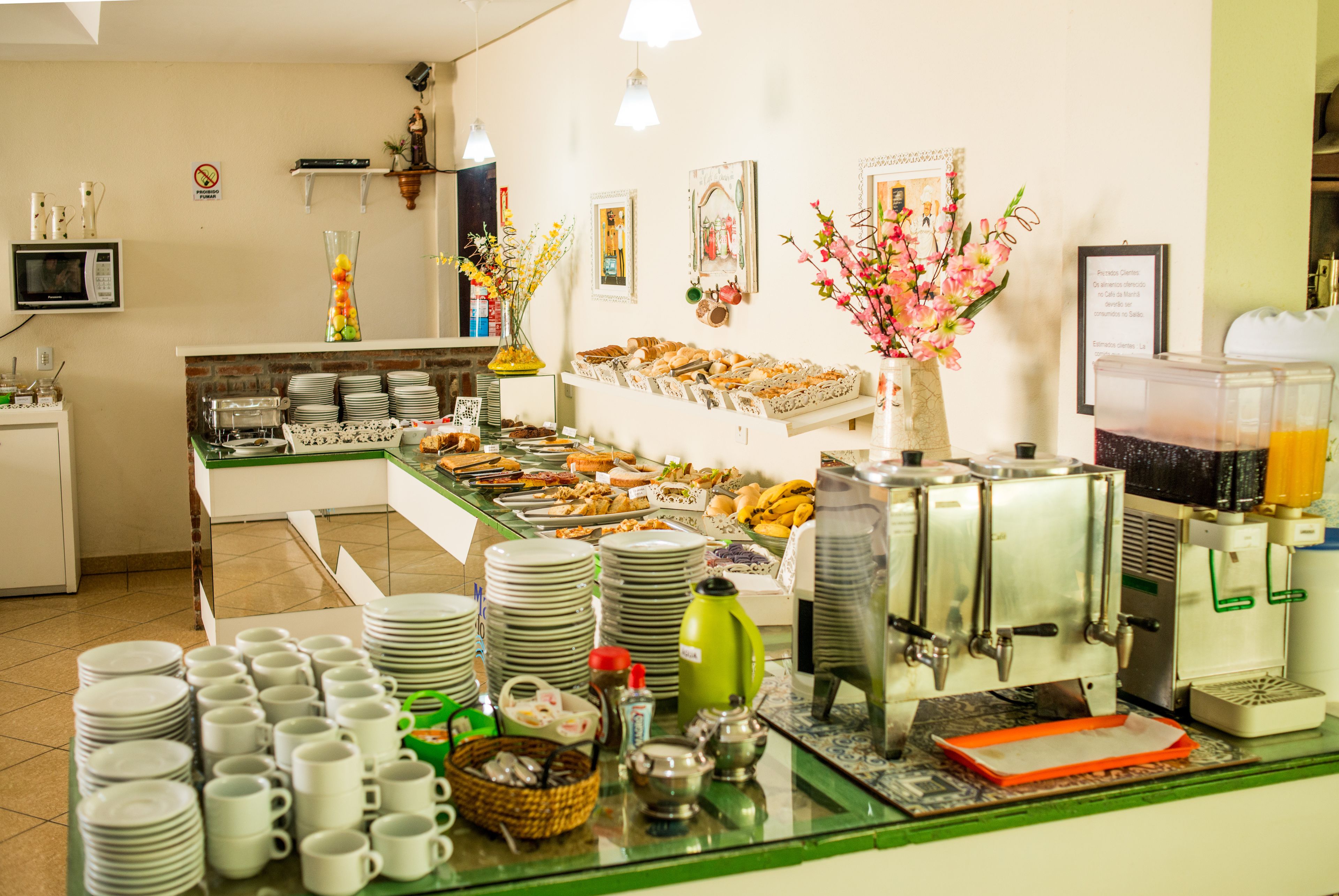 A buffet setup with various food items, a coffee machine, and a microwave.