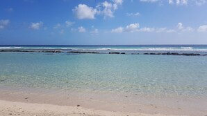 A beach with clear turquoise water, a sandy shore, and rocky outcrops in the distance. - Palm Beach Condo 202  - A Vacation Rental by Bougainvillea Barbados (Hastings)