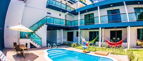 Una piscina al aire libre, sillones reclinables de piscina