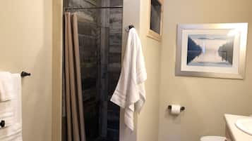 Une salle de bain avec douche, toilettes et lavabo.