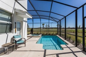 A covered outdoor swimming pool with a view of the surrounding landscape. - 5BR Pool Home in Storey Lake by SHV-4817 (Kissimmee)