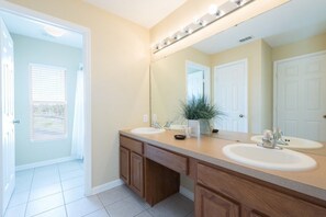 A bathroom with two sinks, a large mirror, and wooden cabinets.