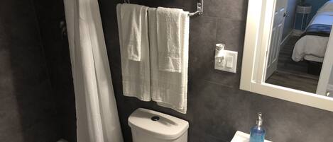 Ein Badezimmer mit Dusche, Toilette und Waschbecken.