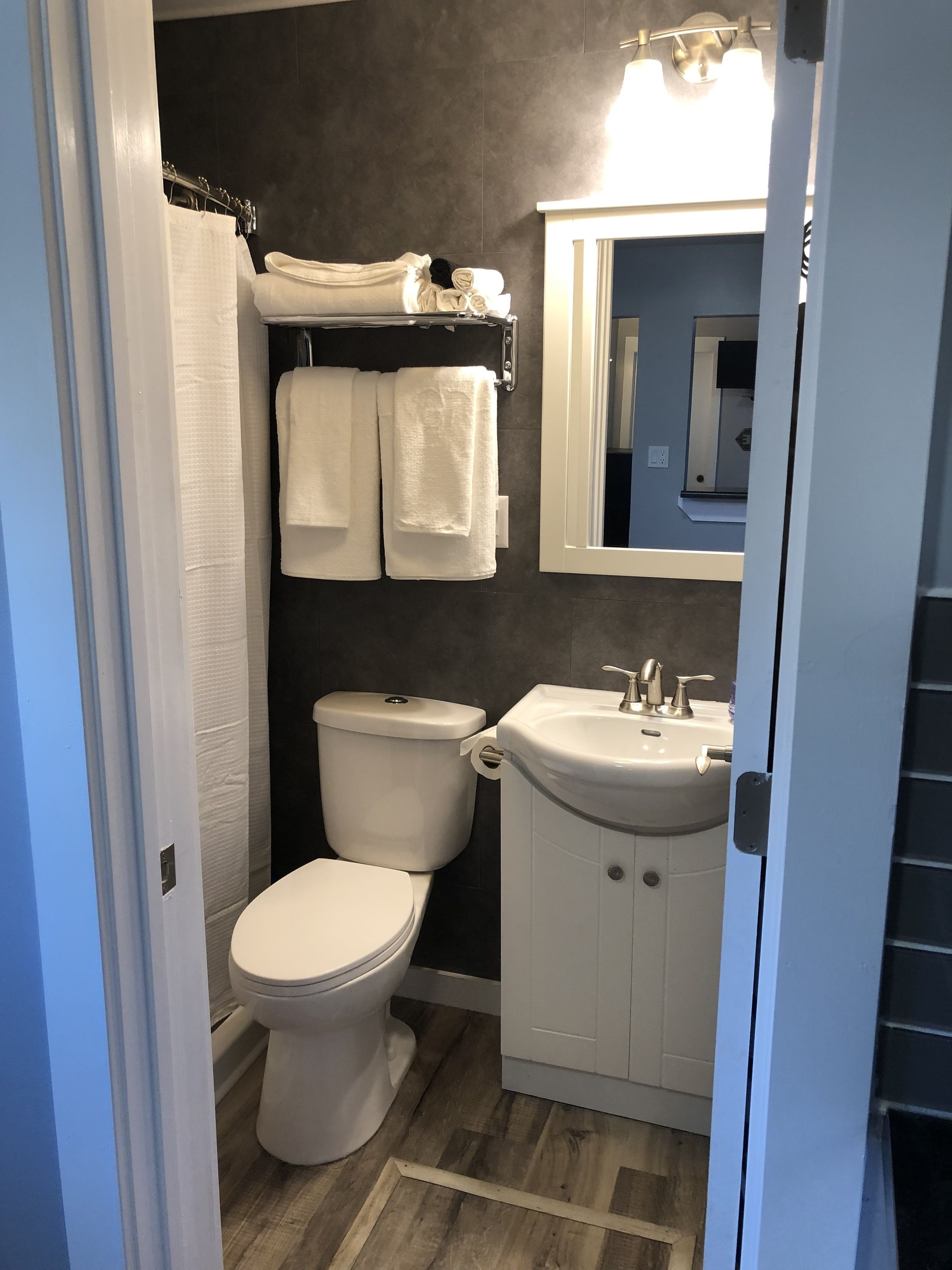 Un baño pequeño con inodoro, lavamanos y barra para toallas.