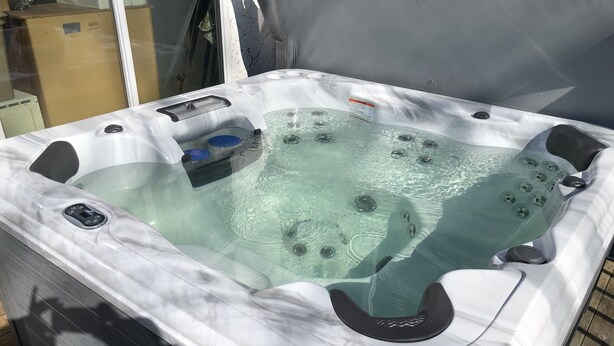 A hot tub with a control panel, a glass top, and a wooden deck surrounding it. - Alexanders Landing (Monticello)