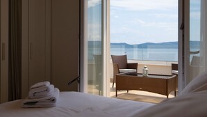 Ein Hotelzimmer mit Bett, Sessel, Tisch und Meerblick.