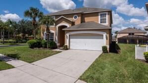 A residential house with a garage, a driveway, and a well-maintained lawn. - 7BR Pool Home Emerald Island by SHV-2793 (Kissimmee)