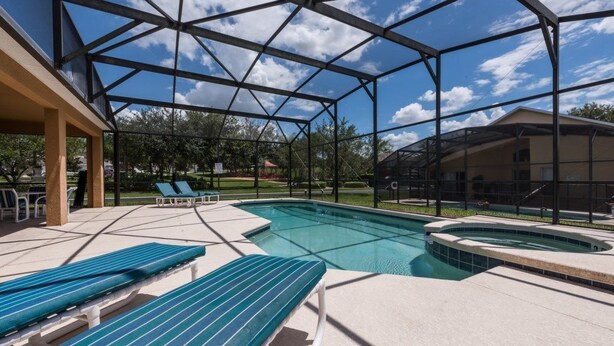 A covered outdoor swimming pool with lounge chairs and a hot tub. - 7BR Pool Home Emerald Island by SHV-2793 (Kissimmee)