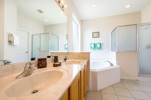 A bathroom with two sinks, a bathtub, and a shower.