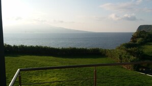 A balcony with a view of the sea and a grassy area. - Azores Beach Home for adults/children, 3 bed.2 bath, First Fl., 3534/AL (Horta, Azores)