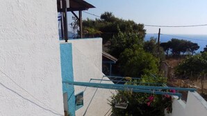 A staircase leading to a covered outdoor area with a view of the sea. - Mary Popi (Kalymnos)