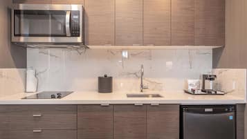 A modern kitchen with a built-in microwave, a coffee machine, and a dishwasher.