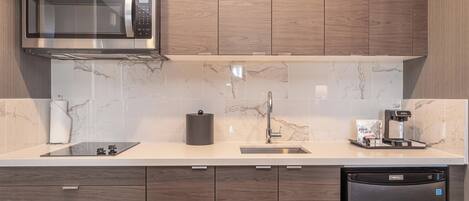 A modern kitchen with a built-in microwave, a coffee machine, and a dishwasher.