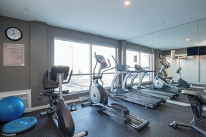 Egy fitneszterem futópadokkal, egy elliptikus trénerrel és egy kék színű gimnasztikai labdával.