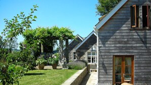 A row of wooden houses with stone walls, a stone pathway, and lush greenery. - The School House, Coryton - a peaceful retreat  (sleeps 6+toddler) (Devon)