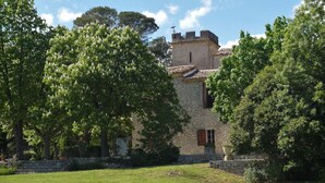 A stone building with a tower, surrounded by lush green trees and a well-maintained lawn. - Loft "Reve d'Evan", design apartment - terrace & spa just for 2 (Carnas)