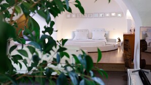 A modern bedroom with a curved bed, white linens, and a minimalist design. - Loft "Reve d'Evan", design apartment - terrace & spa just for 2 (Carnas)