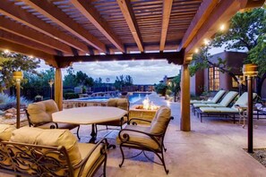 An outdoor patio with a pool, lounge chairs, and a fire pit. - Los Valverde - Exclusive Luxury Home, Unsurpassed Views, Pool and Hot Tub! (Santa Fe)