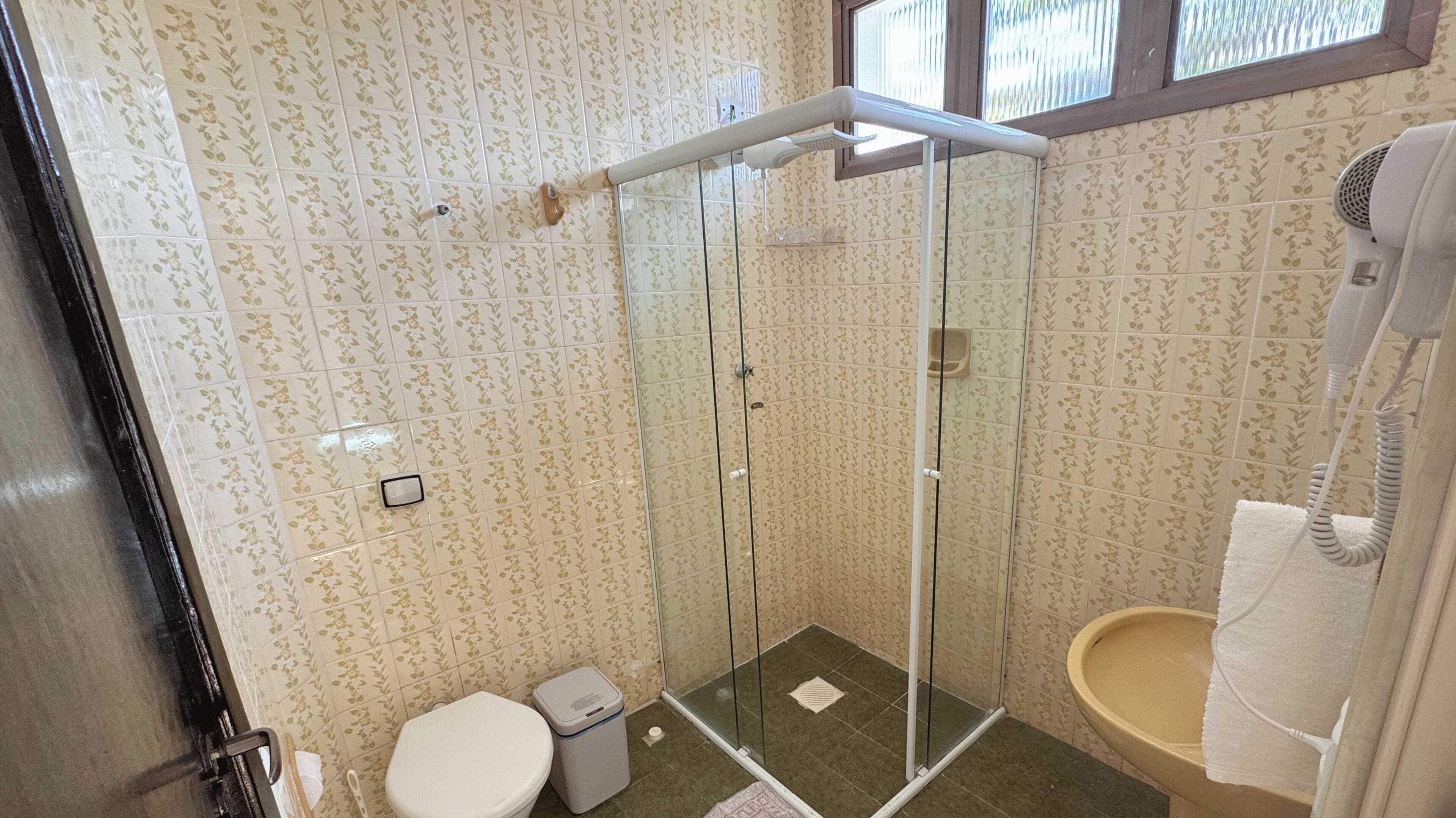 A bathroom with a glass shower enclosure, a toilet, a bidet, and a sink.