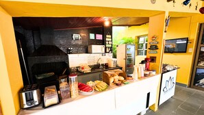 Ein Frühstücksbuffet mit Kaffeemaschine, Toaster und verschiedenen Speisen.