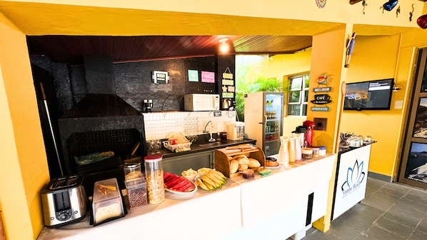 A breakfast bar with a coffee machine, toaster, and various food items.