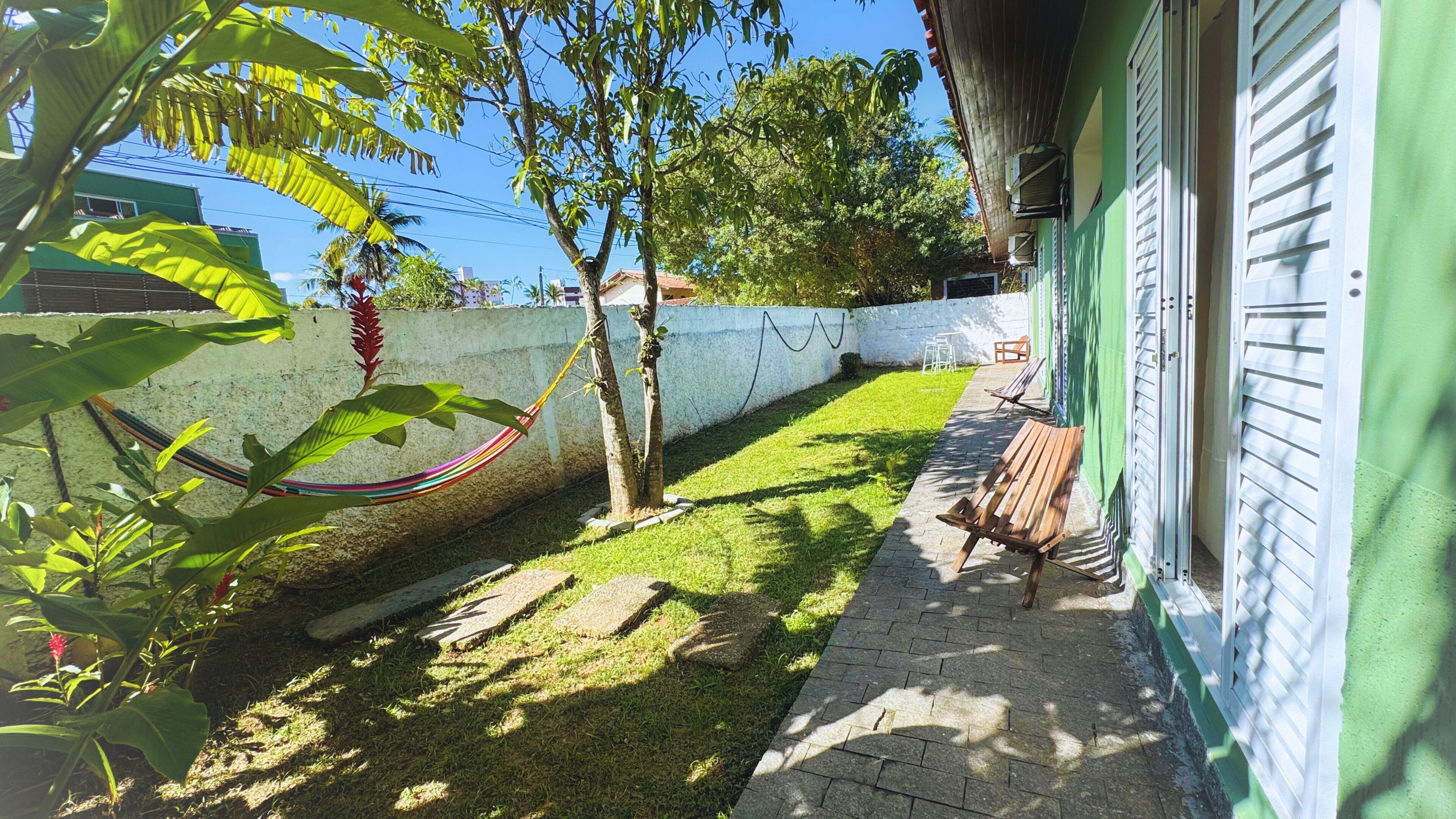 A patio with a hammock, a bench, and a small garden area.