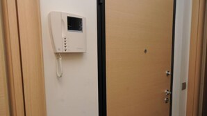 A room with a wooden door, a white wall-mounted telephone, and a door handle. - Comfortable Apartment in a Residence Code CIR 015209-CIM 00116 (Sesto San Giovanni)
