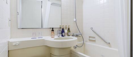 Un baño con lavamanos, espejo, ducha e inodoro.