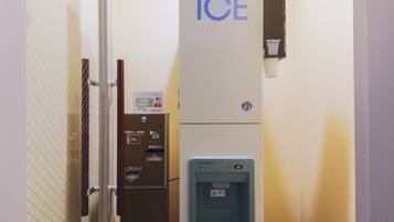 A vending machine with a drink dispenser, a card reader, and a sign indicating a VOD room theater.