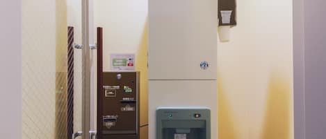 Una máquina expendedora con dispensador de bebidas, lector de tarjetas y un cartel que indica una sala de cine VOD.