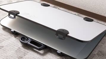 A suitcase with wheels and a handle, placed on a textured carpet.