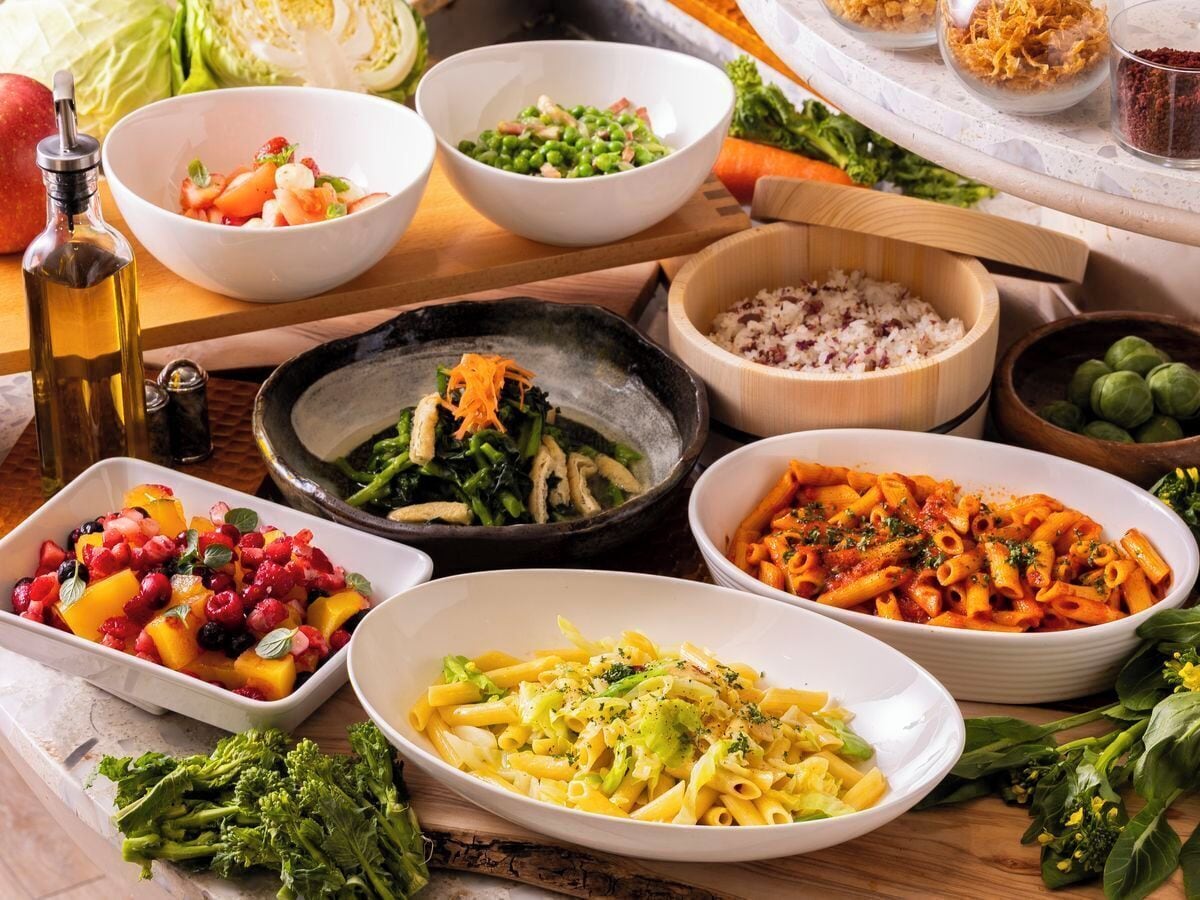 A variety of dishes including pasta, salads, and vegetables on a table.