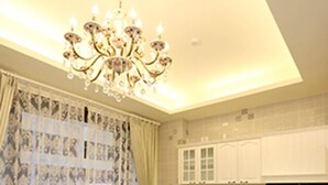 A kitchen with white cabinets, a chandelier, and a dining table with chairs. - When Happiness Knock Your Door (Hualien City)