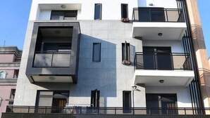 A modern multi-story building with balconies, large windows, and a stone facade. - When Happiness Knock Your Door (Hualien City)