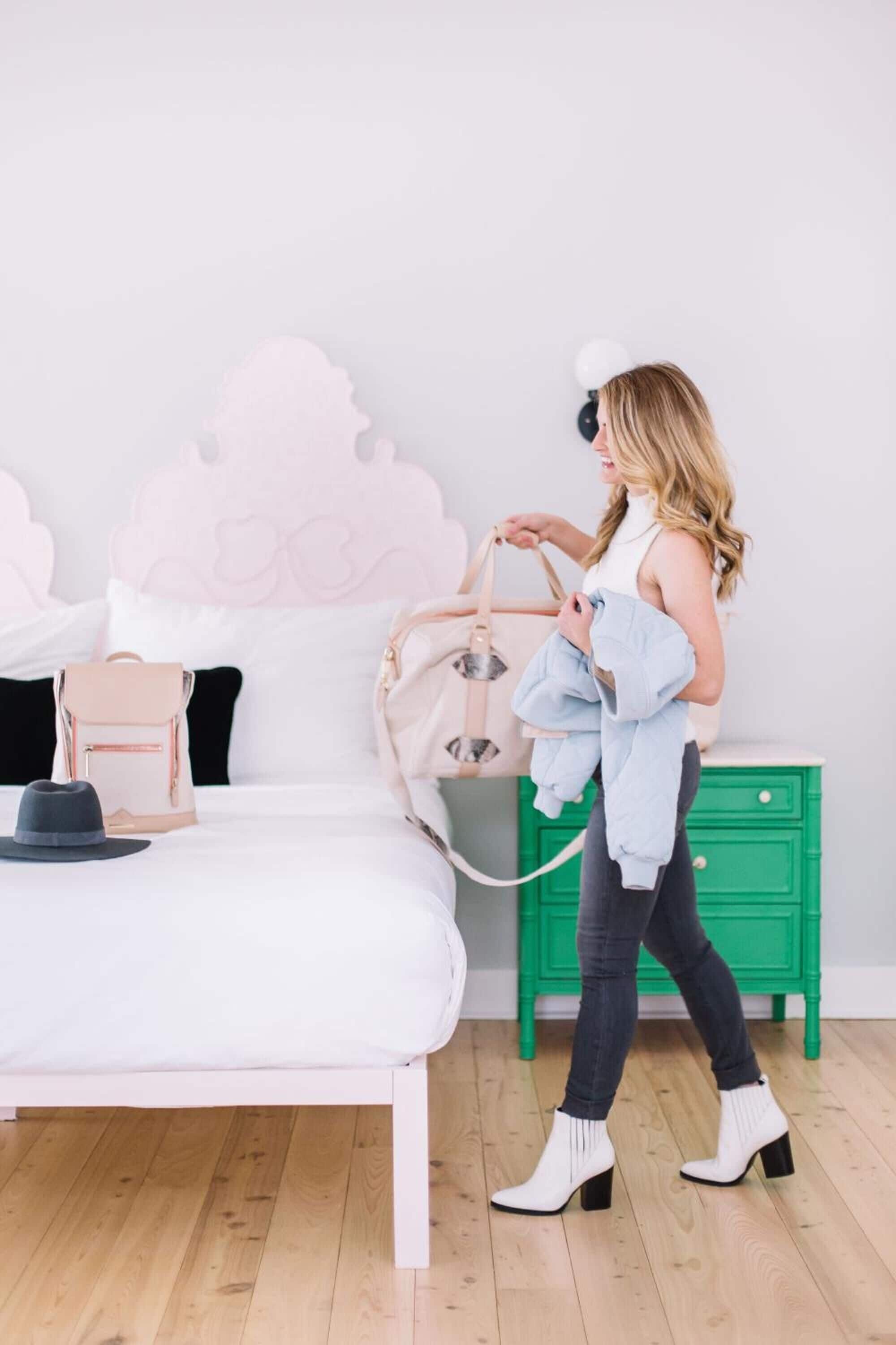 A bedroom with a white bed, a green nightstand, and a pink decorative headboard.