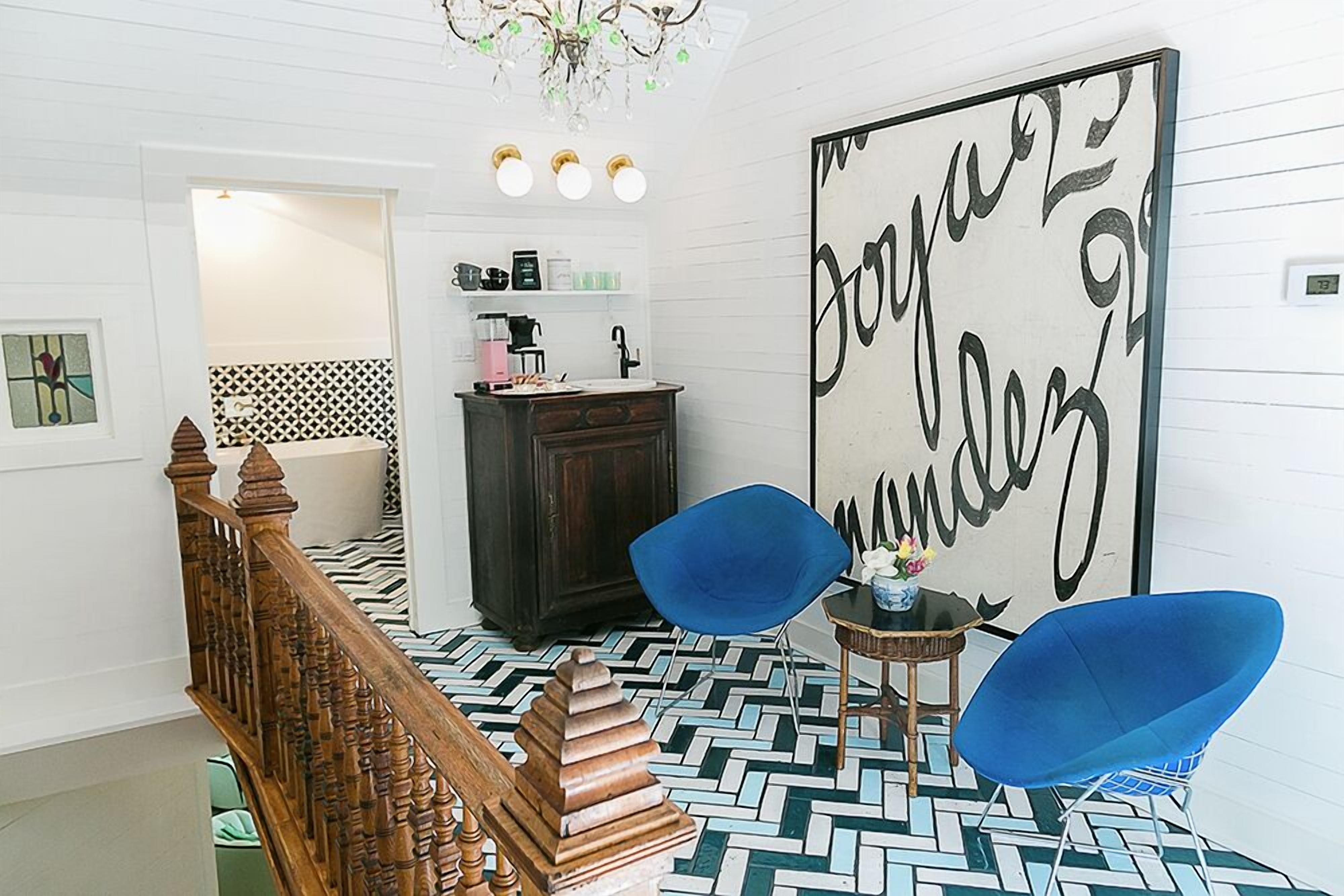 Ein modernes Interieur mit einer Treppe, einem großen Wandkunstwerk und einem gemusterten Boden.