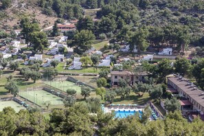Un quartier résidentiel avec des villas, un court de tennis et une piscine.