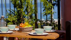 A wooden table set with bowls, a basket of fruit, and a bottle. - Unique oceanfront retreat with fantastic views of the wild natural space (Carballo)