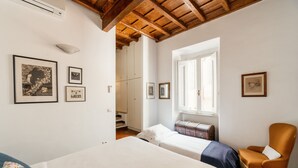 Ein Schlafzimmer mit einem Bett, einem Sessel und einem Fenster.