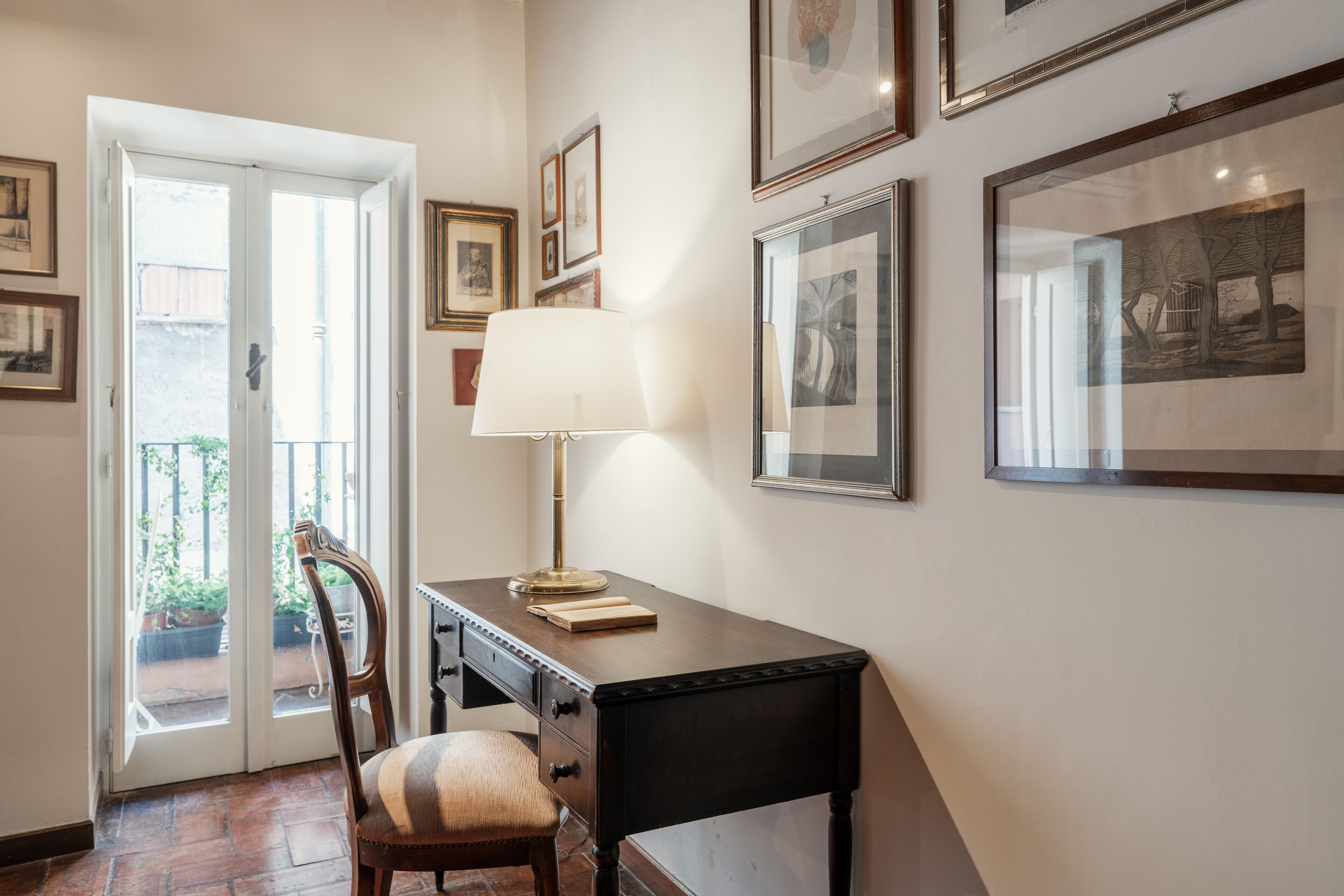 A hallway with a desk, chair, and a door leading to an outdoor area.